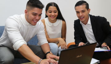 Estudiantes reunidos frente a un computador portátil