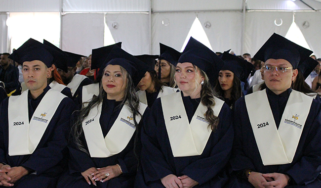 Estudiantes graduados de UNIMINUTO sentados en la ceremonia.