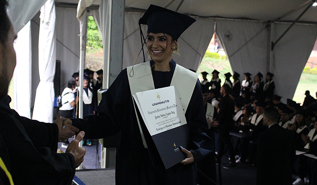 Estudiante recibiendo su diploma de carrera profesional en ceremonia. 