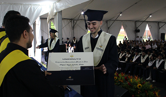 Estudiante recibiendo su diploma de carrera profesional en ceremonia. 