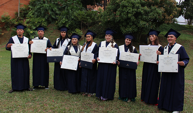Estudiantes graduados en el Campus Bello con sus respectivos diplomas.
