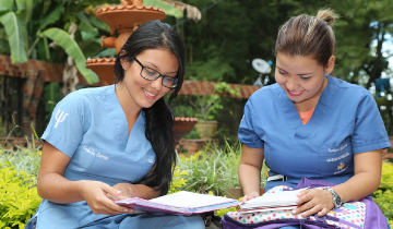 Mujeres con uniformes azules, estudiando al aire libre