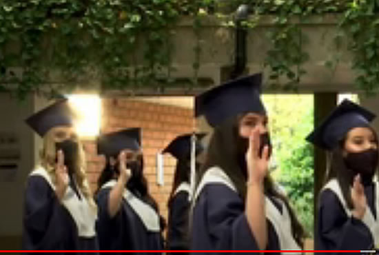 Graduados de Antioquia con toga, birrete y tapabocas