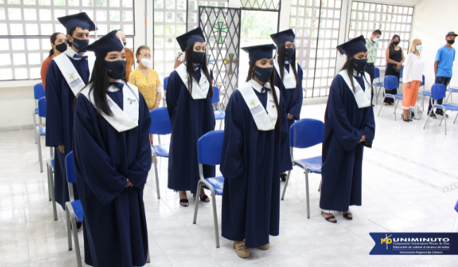 Estudiantea de pie con toga en la ceremonia