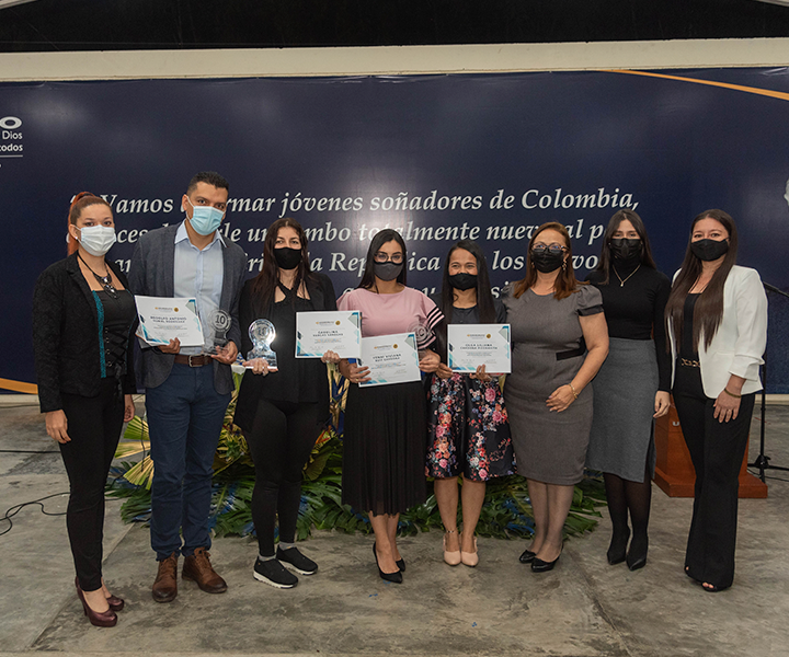 Los ganadores del concurso de experiencia ssignificativas, sostienen su estatuilla y diploma