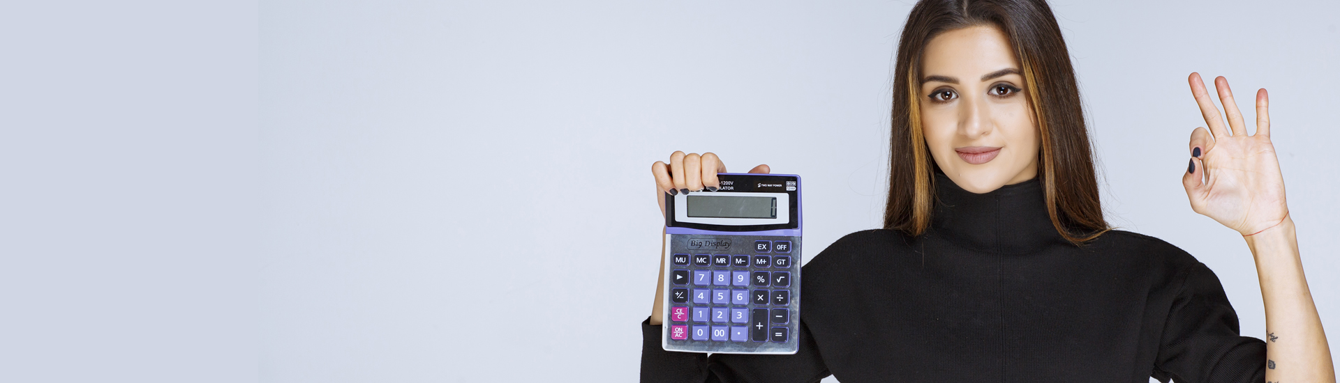 Mujer muestra una calculadora con su mano derecha, mientras con la izquierda realiza gesto de aprobación 