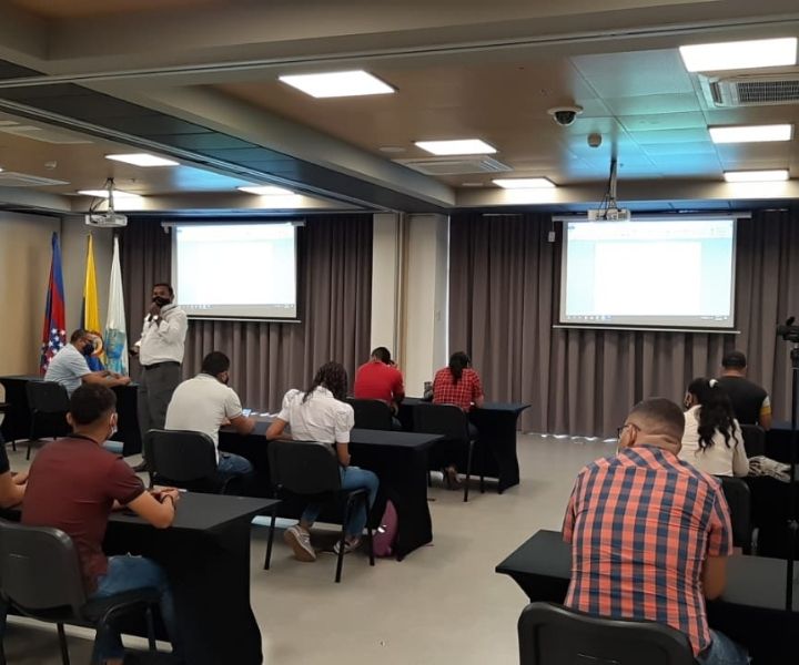 Grupo de personas en un salón recibiendo una charla