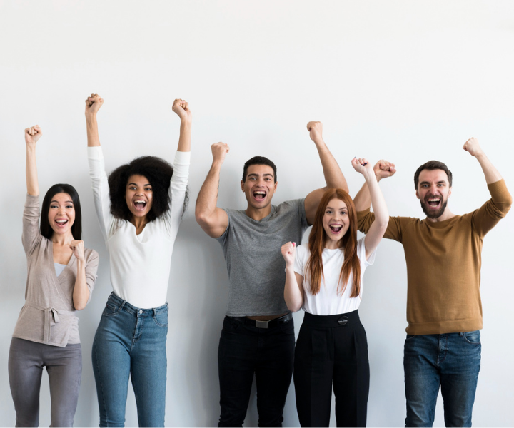 Jóvenes eufóricos, levantando los brazos con expresión en el rostro de felicidad y orgullo. Fondo blanco-gris