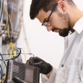 Joven manipulando cableado y redes de cómputo desde un RAC