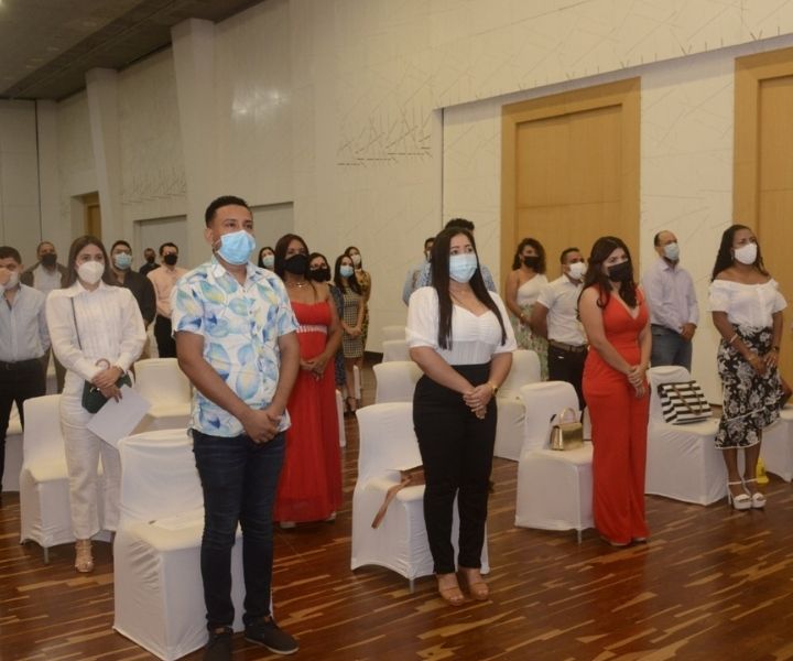 Varios personas de pie en un auditorio 