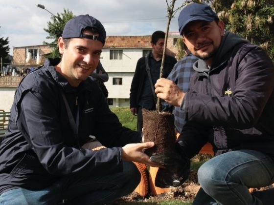 Dos hombres sembrando una planta 