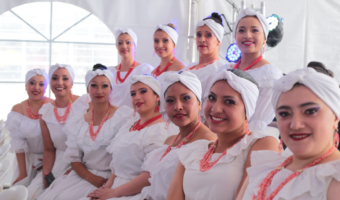 Grupo de mujeres posando para la cámara antes de su presentación. 