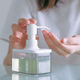 Joven aplicándose jabón/gel antibacterial en las manos. 