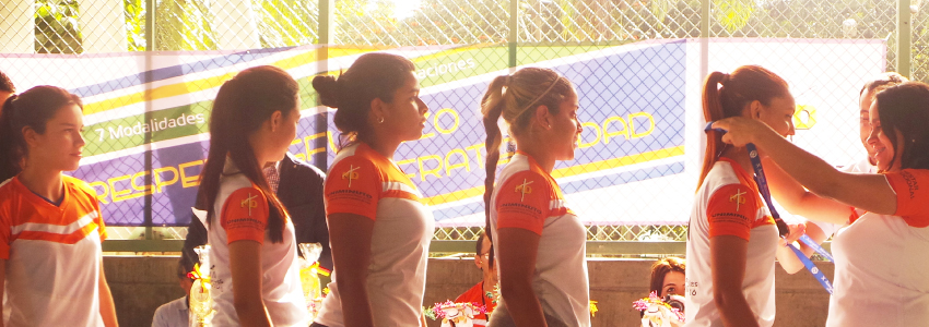 Equipo femenino en fila para recibir las medallas. 