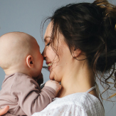 Madre feliz, cargando a su bebé. 