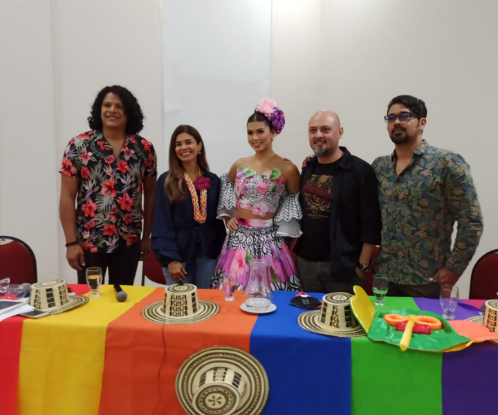 Reina del carnaval de Barranquilla con una mujer y tres hombres de pie detrás de una mesa