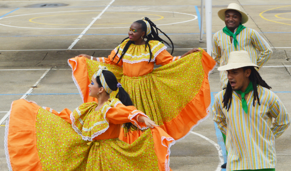 Dos parejas de baile con trajes típicos coloridos. 
