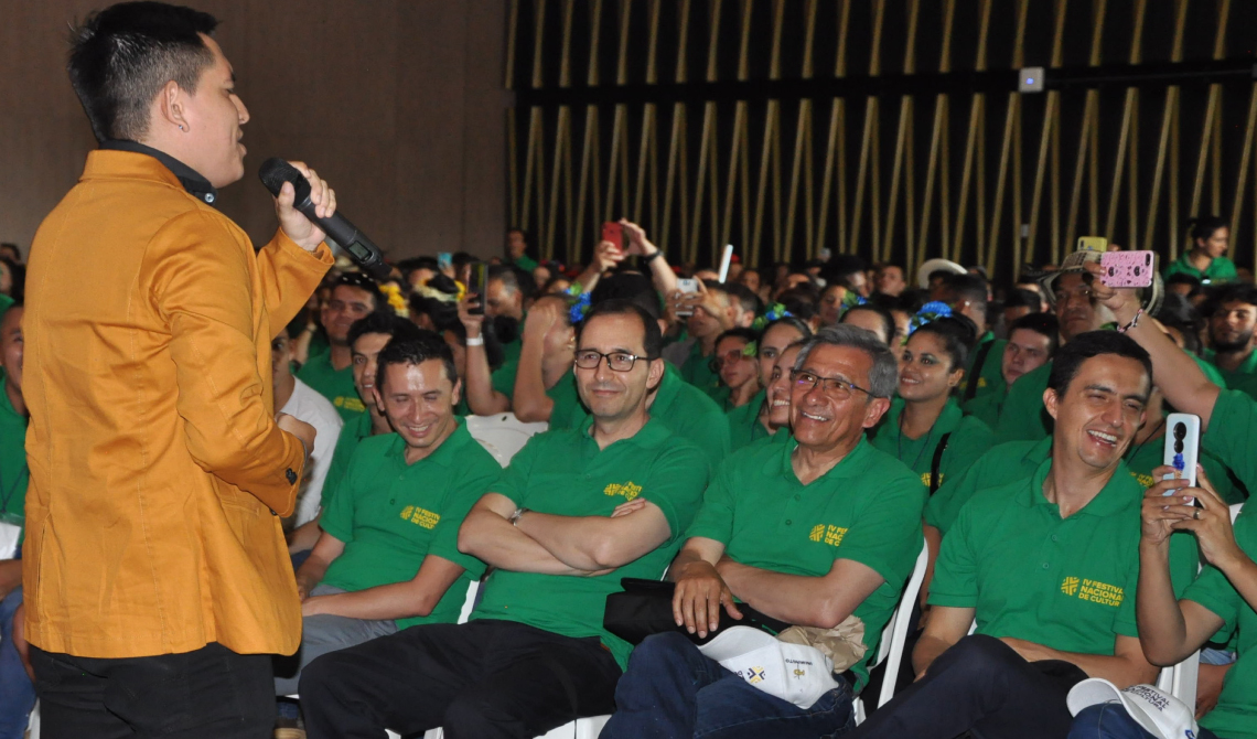 Concursante hombre en medio de su presentación frente al público alegre del auditorio. 