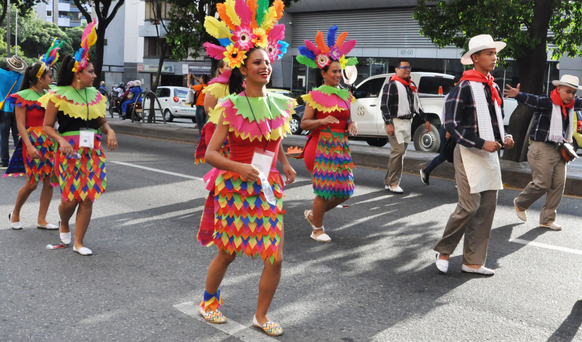 Grupo de danza mixto, usando coloridos vestidos.