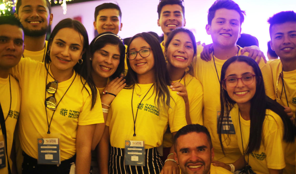 Estudiantes con camisetas amarillas posando alegres para la cámara.