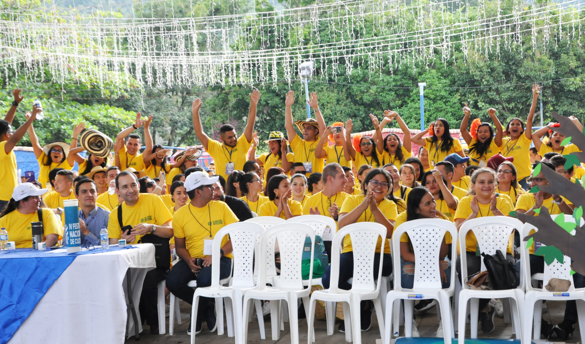 Estudiantes con camisetas amarillas ovacionando su delegación. 