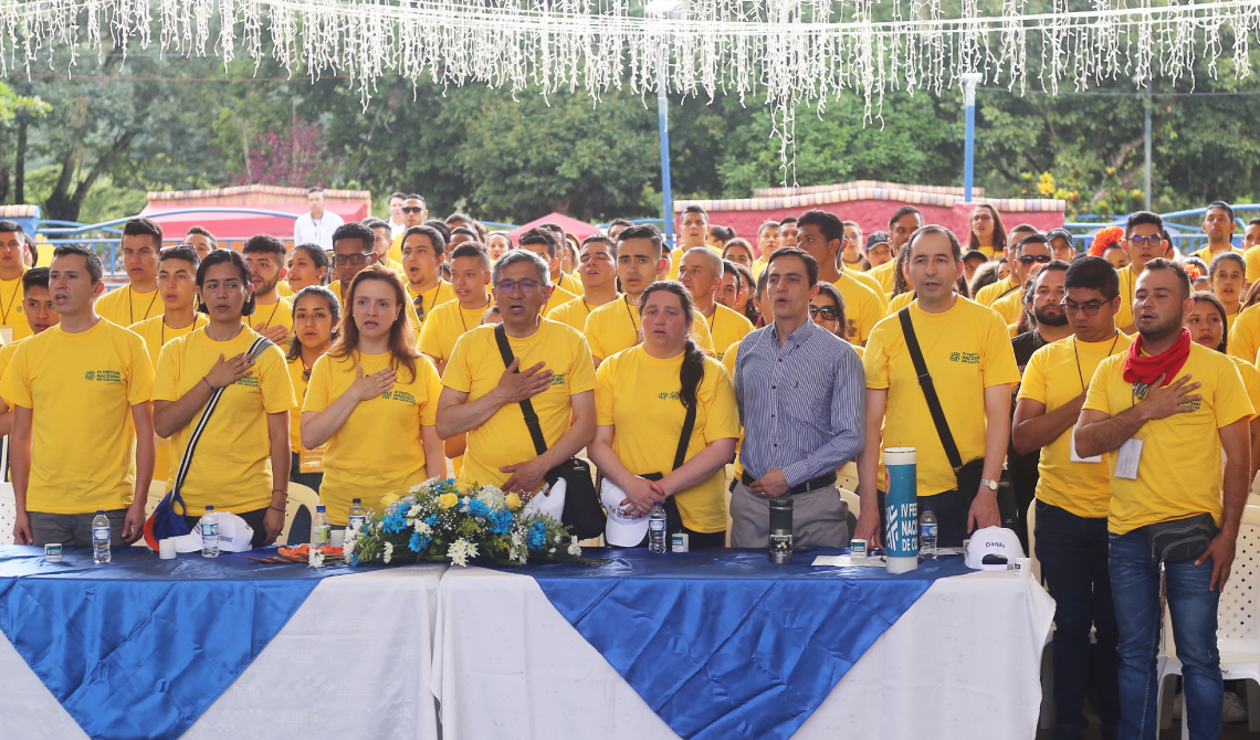 Colaboradores y estudiantes entonando el himno nacional de la República de Colombia.
