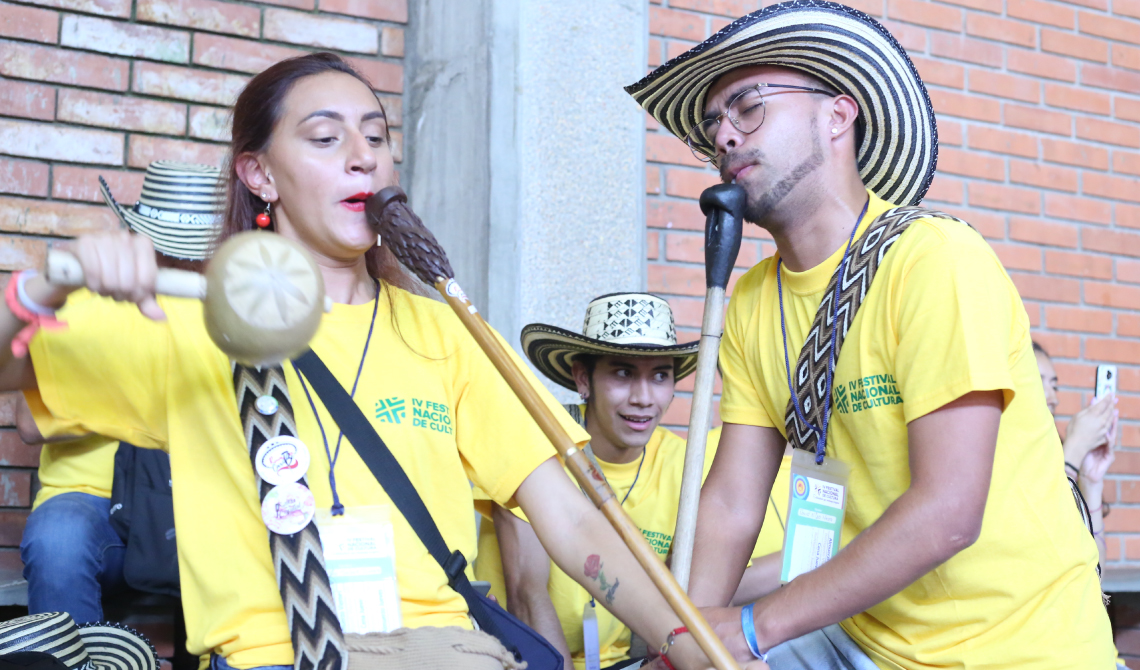 Pareja de música interpretando con sentimiento la gaita.