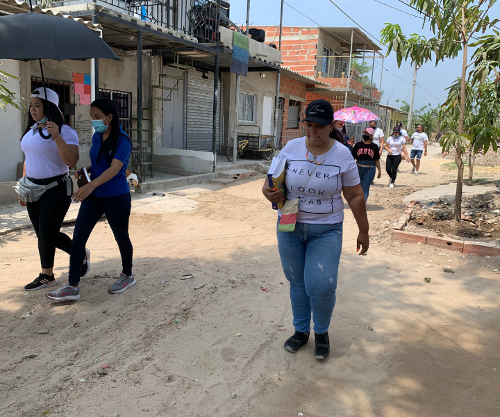 Jóvenes caminando sobre una calle destapada 