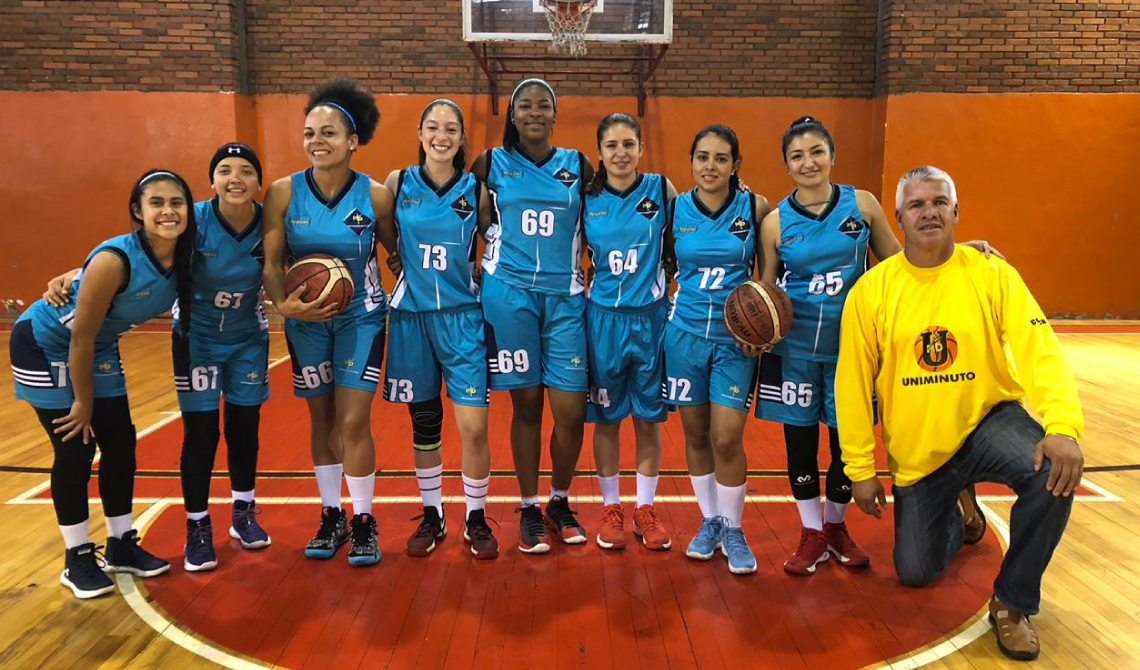 Equipo femenino de baloncesto y su director técnico, posando para la cámara.