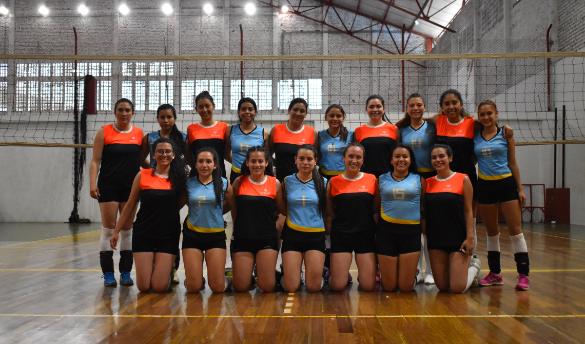 Equipos femeninos de voleibol posando para la cámara antes de competir.