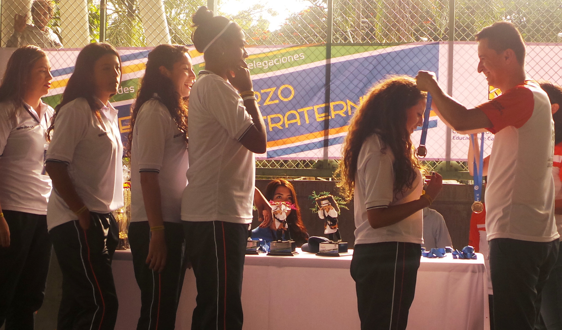 Equipo femenino recibiendo las medallas de reconocimiento. 