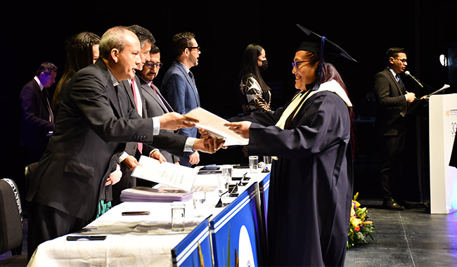 Estudiante mujer recibiendo su diploma de grado