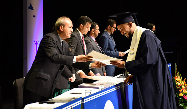 Estudiante hombre recibiendo su diploma de graduación