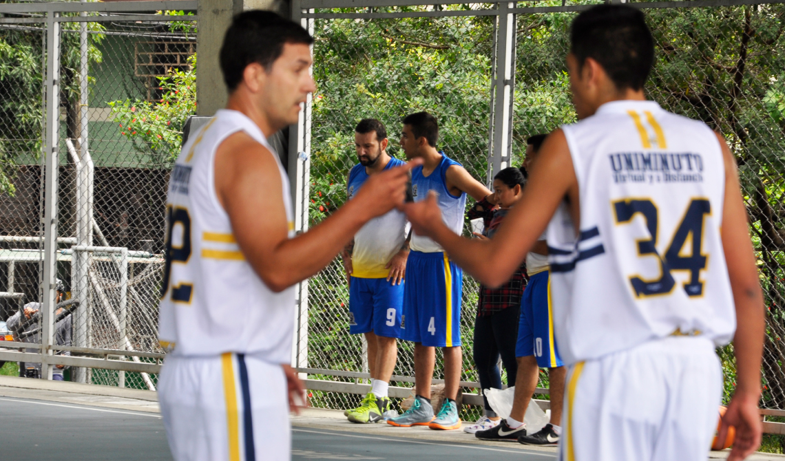Dos integrantes del equipo de baloncesto de UBVD comentando acerca del juego en curso.