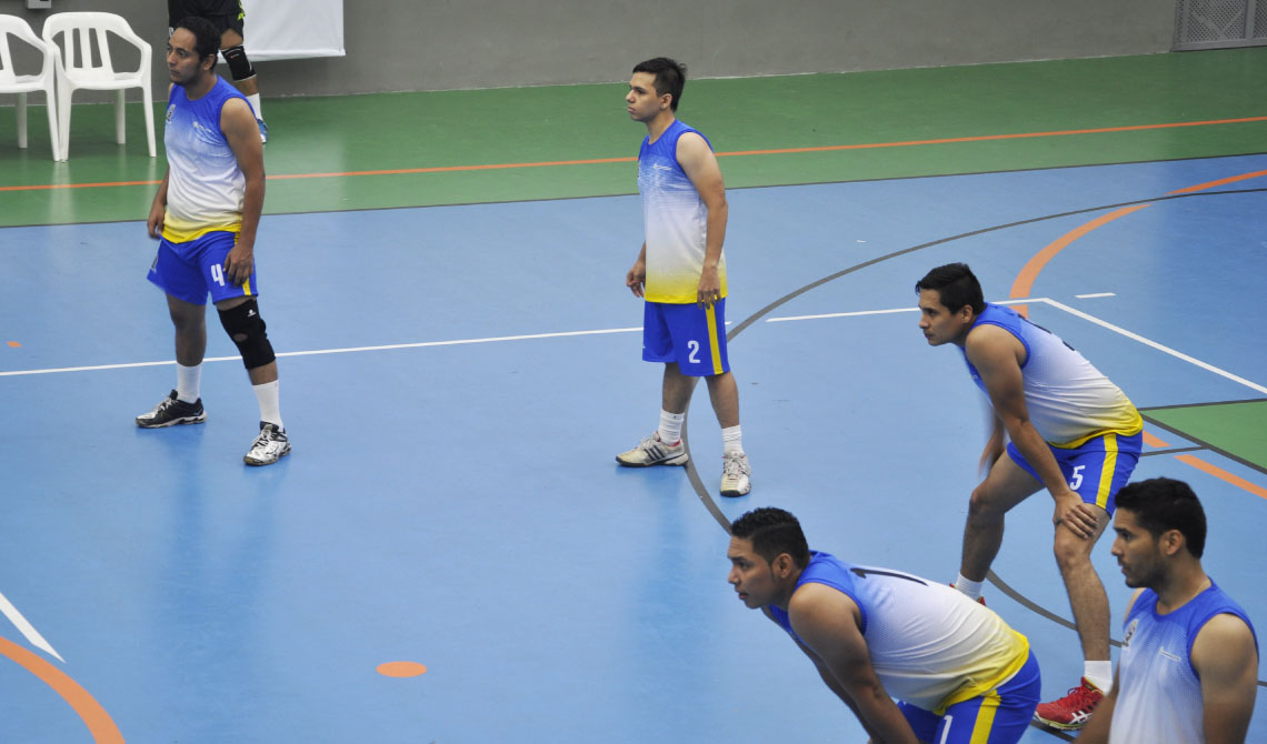 Equipo de voleibol masculino en medio de la competencia.
