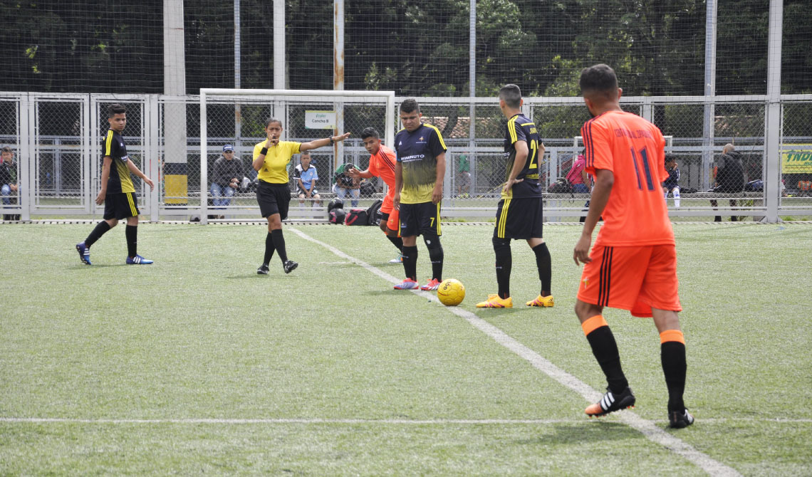 Árbitro pintando en competencia de fútbol masculino. 