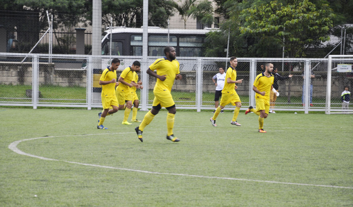 Equipo de fútbol masculino trotando en la cancha. 