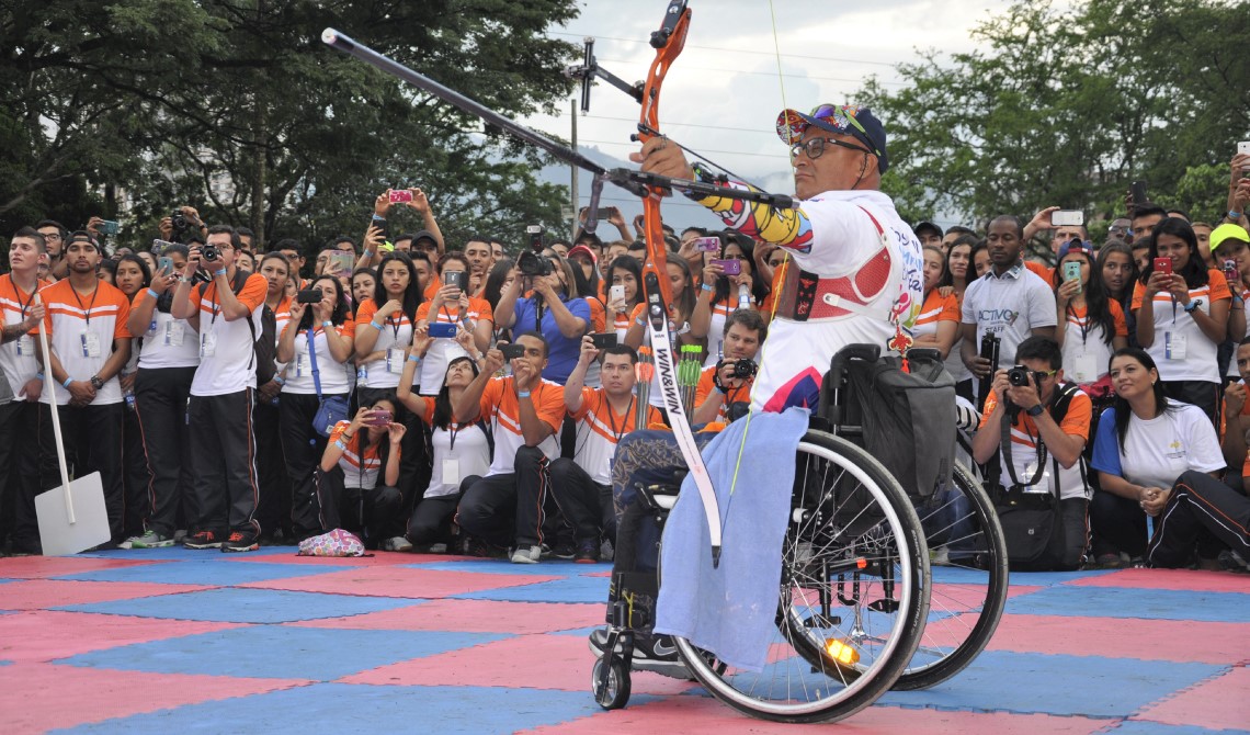 Campeón de arco paraolímpico realizando una demostración al público. 