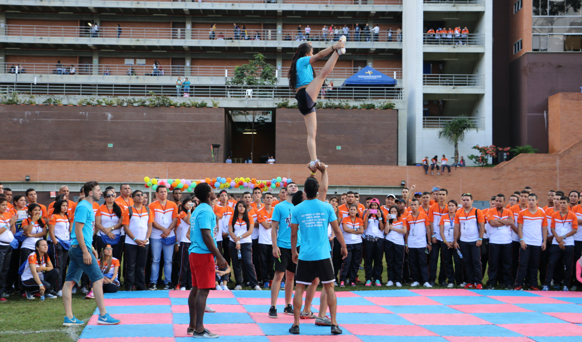 Grupo de gimnasia realizando su presentación en medio del campus. 