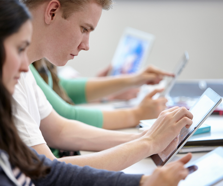 Jóvenes en clase con dispositivos móviles