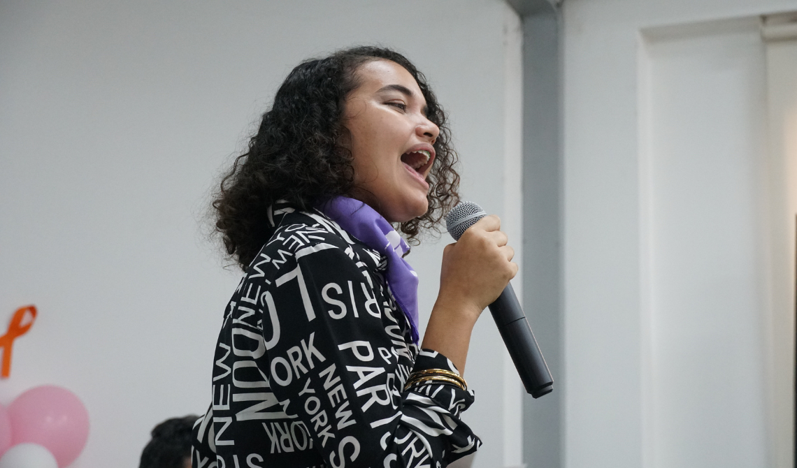 Mujer joven cantando, en primer plano.