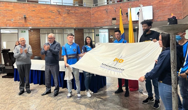 Estudiantes de las delegaciones sostienen bandera 