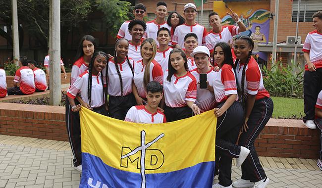 Deportistas sosteniendo la bandera de UNIMINUTO