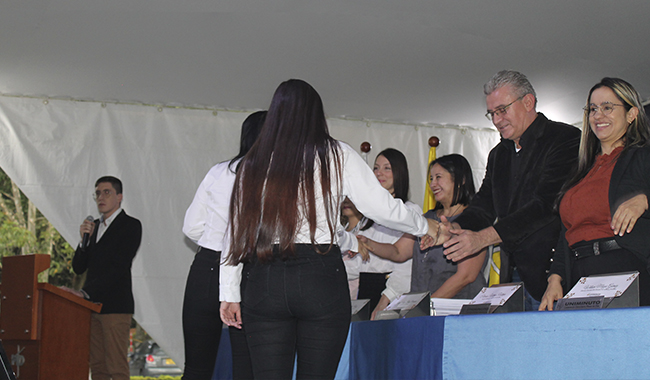 Estudiante recibiendo su certificado de beca UNIMINUTO