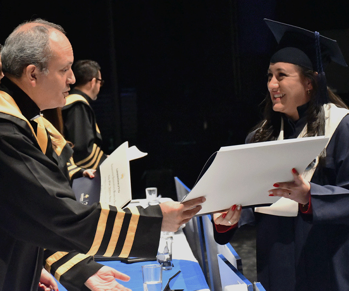 Estudiante recibeindo diploma de grado