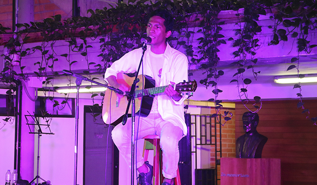 Cantante interpretando una canción acompañado por su guitarra