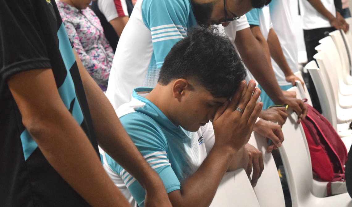 Estudiante arrodillado orando