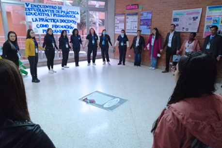 Grupo de estudiantes cogidos de la mano haciendo mesa redonda