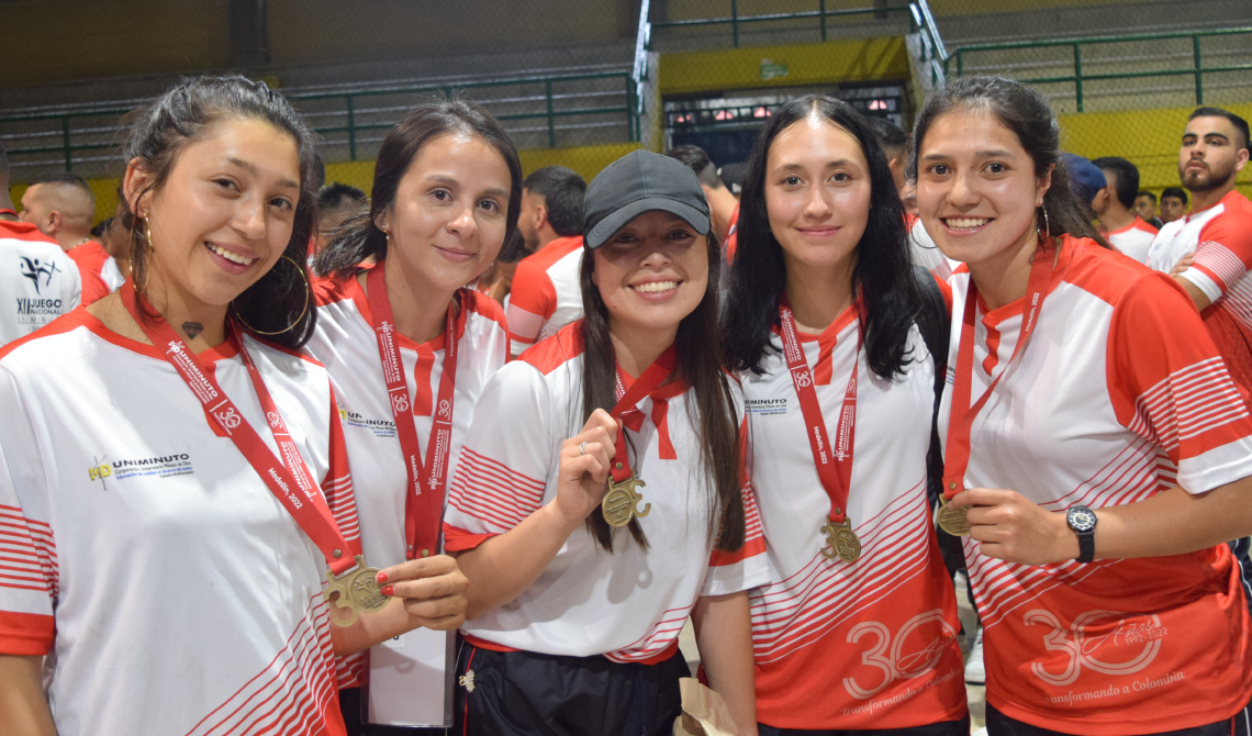 Deportistas mujeres exhibiendo su medalla