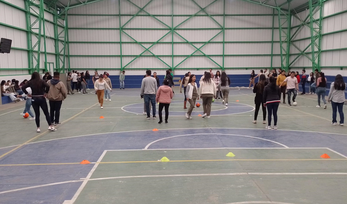 Personas realizando una actividad en un coliseo.